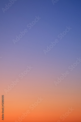 Gradient of sunset sky from red-orange to blue, vertical photo