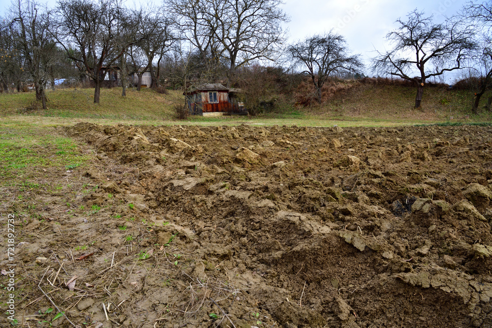 Wooden farm house with a field for planting in the village traditionally