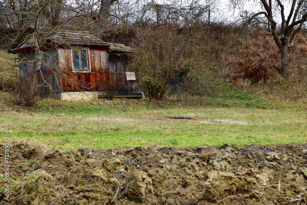 Wooden farm house with a field for planting in the village traditionally