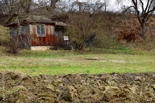 Obraz na płótnie Wooden farm house with a field for planting in the village traditionally w salonie