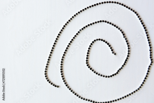 Chain of crystals in a spiral on a wooden background