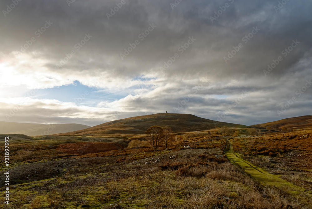 Looking from the Footpath to the Maule Monument at Tarfside towards the Hill of Rowan in Upper Glen Esk with the low sun spreading shadows across the Moorland.