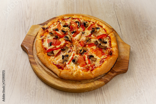Chicken pizza with mushrooms. On a light wooden background.