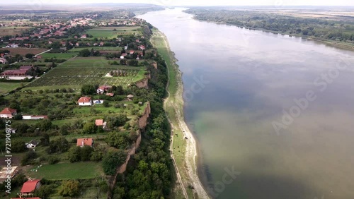 Danube river flows through village Surduk, Serbia in cloudy day photo