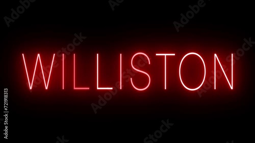 Flickering red retro style neon sign glowing against a black background for WILLISTON photo