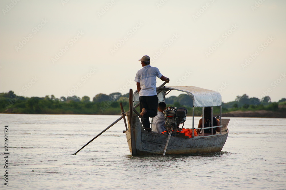 Boat Driver and Tourists on the lookout for Dolphins (Mekong River, Kratié, Cambodia) 