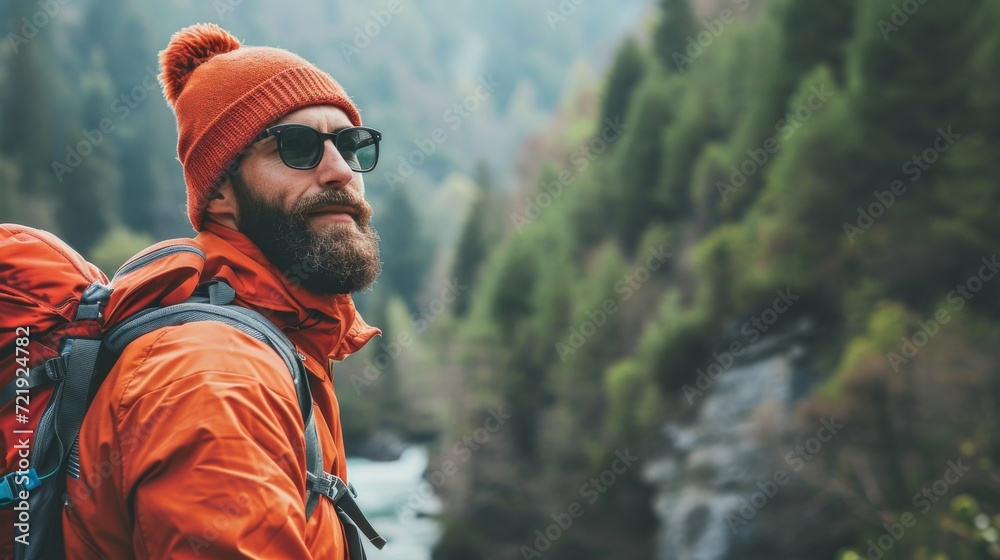 A rugged man clad in an orange jacket and hat stands amidst a lush forest, his determined expression reflecting his love for the great outdoors and his adventurous spirit