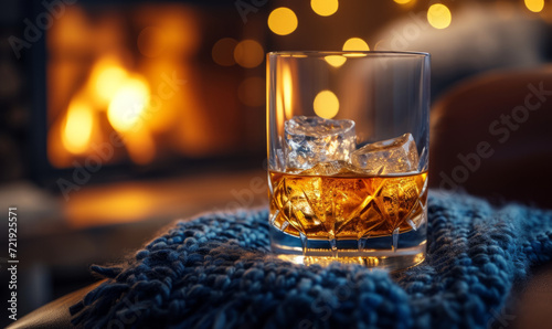 Whisky on the rocks in a cozy room with a roaring fireplace. Comfort and winter warmth concept. Design for home lifestyle branding and intimate gathering promotions