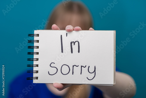 Odręczny napis przepraszam na białej kartce trzymany przez dziewczynę 