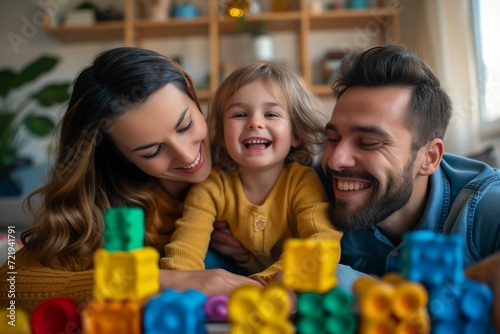 Cheerful young family of three having fun, playing with toys together at home