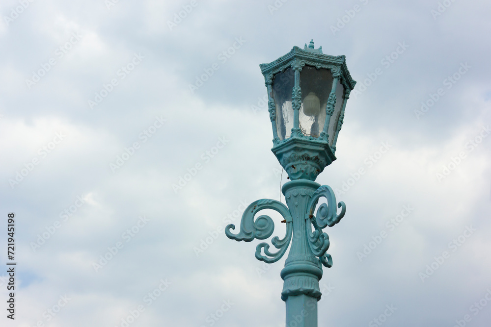 Antique blue lamp isolated on sky background, cloudy