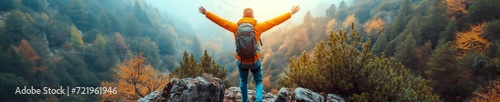 A man with  hand up jumping on the top of the mountain