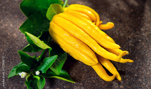 Buddha hand citrus fruit. Yellow Organic fingered citron, Buddha's Hand Citrus Fruit with Fingers, flowers and leaves of plant. Aromatherapy concept 