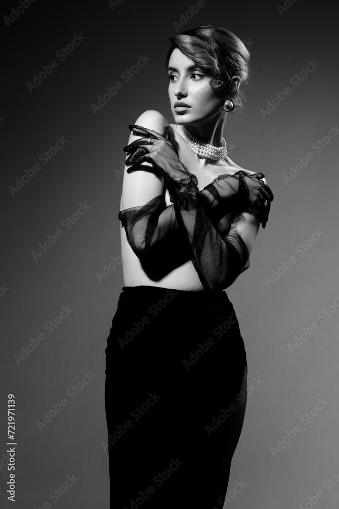 Beautiful luxury young woman with clean skin covering her nude breast. Studio grey background