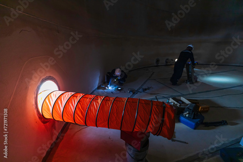 Fototapeta Naklejka Na Ścianę i Meble -  Male worker inside the  tank storage visual inspection tank into the confined space is the blower