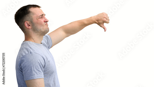 A man in a gray T-shirt, on a white background, close-up, shows his thumbs down