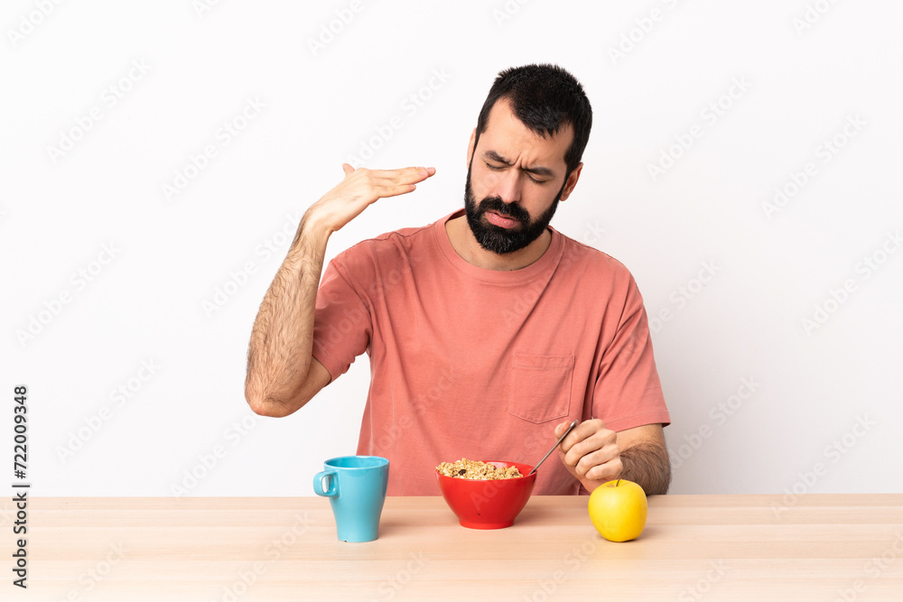 Caucasian man having breakfast in a table with tired and sick expression. Caucasian man having breakfast in a table with tired and sick expression.