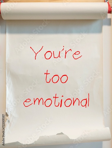 Paper roll with handwriting YOU ARE TOO EMOTIONAL - gaslighting way to accuse or emotional abuse others to question their beliefs or doubt their perception and become distressed photo