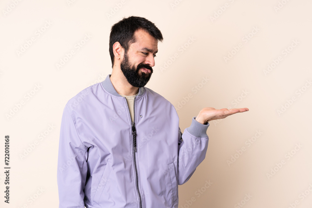 Caucasian man with beard wearing a jacket over isolated background holding copyspace with doubts Caucasian man with beard wearing a jacket over isolated background holding copyspace with doubts