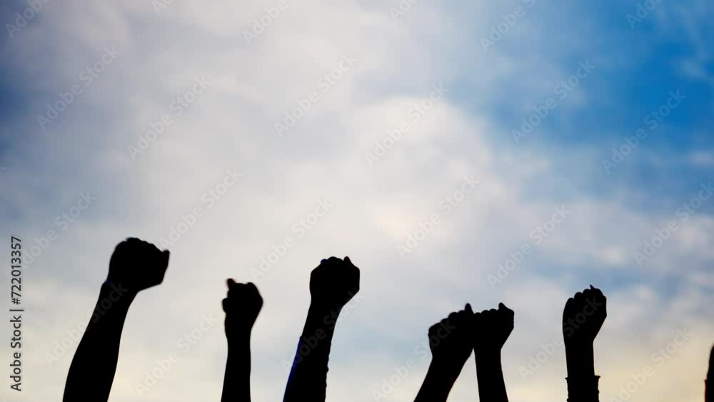 Silhouette on sky of hands of people waving in the air