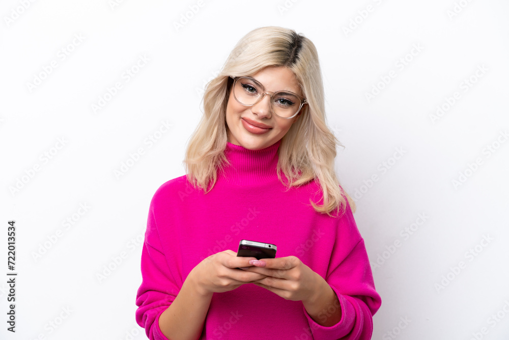Young Russian woman isolated on white background sending a message with the mobile Young Russian woman isolated on white background sending a message with the mobile