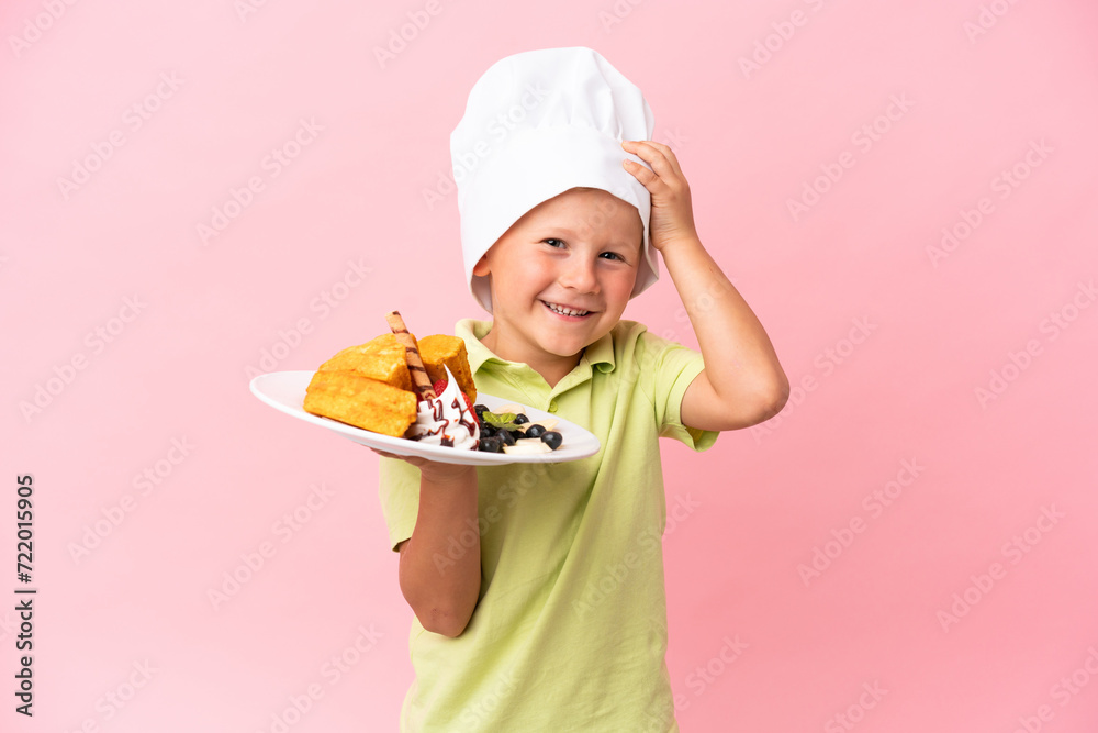 Little Russian boy holding waffles over isolated background Little Russian boy holding waffles over isolated background