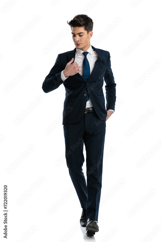 sexy fashion man holding hand in pocket and adjusting suit sexy fashion man holding hand in pocket and adjusting suit