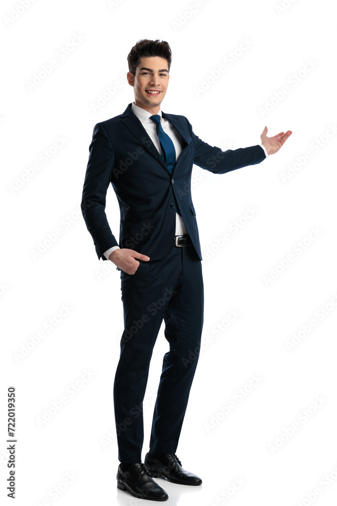 proud elegant man smiling, presenting to side while holding one hand in pocket proud elegant man smiling, presenting to side while holding one hand in pocket