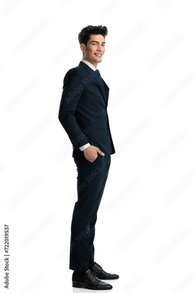 happy young businessman waiting in line and smiling with hands in pockets happy young businessman waiting in line and smiling with hands in pockets