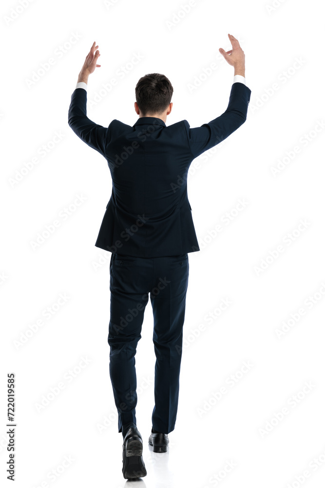 excited elegant businessman with arms above head cheering the victory excited elegant businessman with arms above head cheering the victory