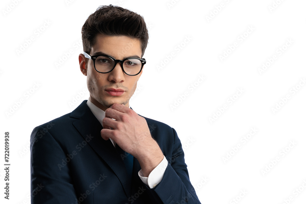 thoughtful young man with glasses in elegant suit touching chin and thinking thoughtful young man with glasses in elegant suit touching chin and thinking