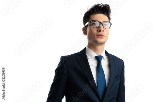 young elegant man with glasses in navy blue suit looking up