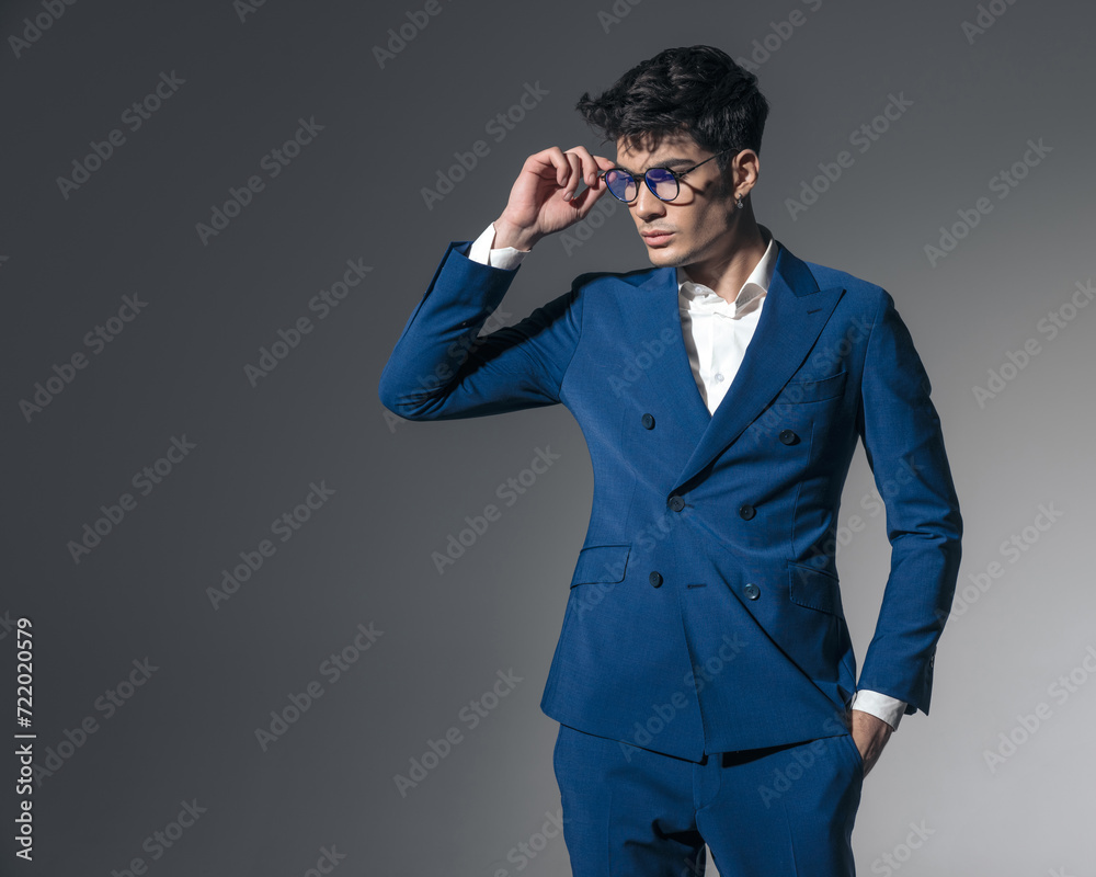 confident businessman with hands in pockets arranging glasses confident businessman with hands in pockets arranging glasses