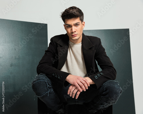 Cuadro en lienzo cool stylish man holding elbows on knees and crouching