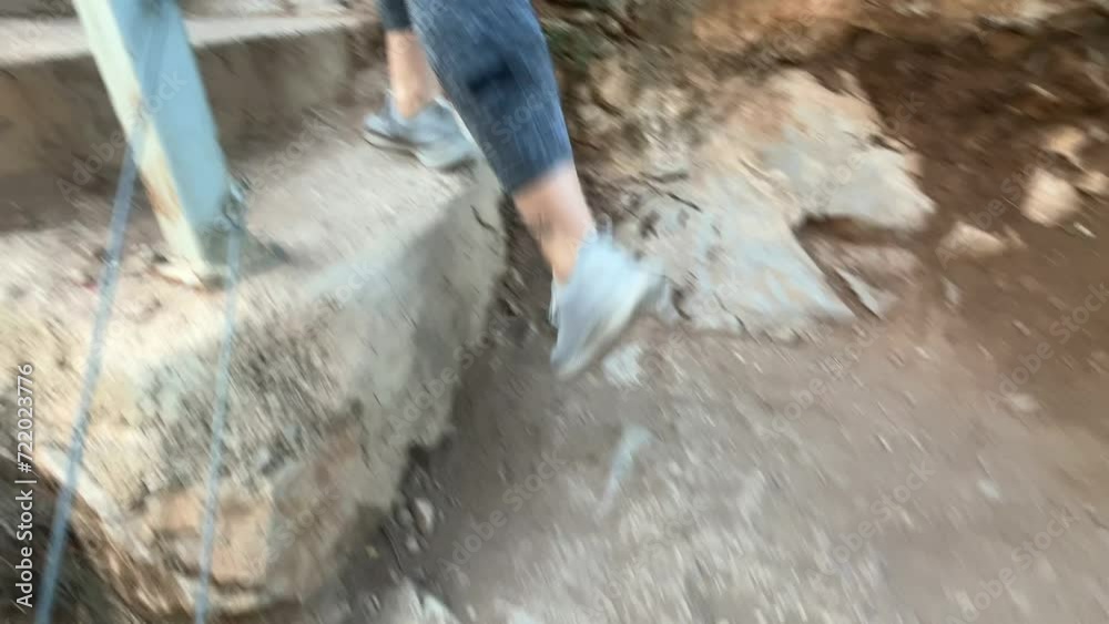 woman's feet climbing stone stairs on mountain route woman's feet climbing stone stairs on mountain route