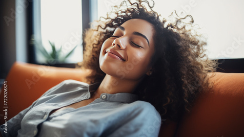 Happy afro american woman relaxing on the sofa at home photo
