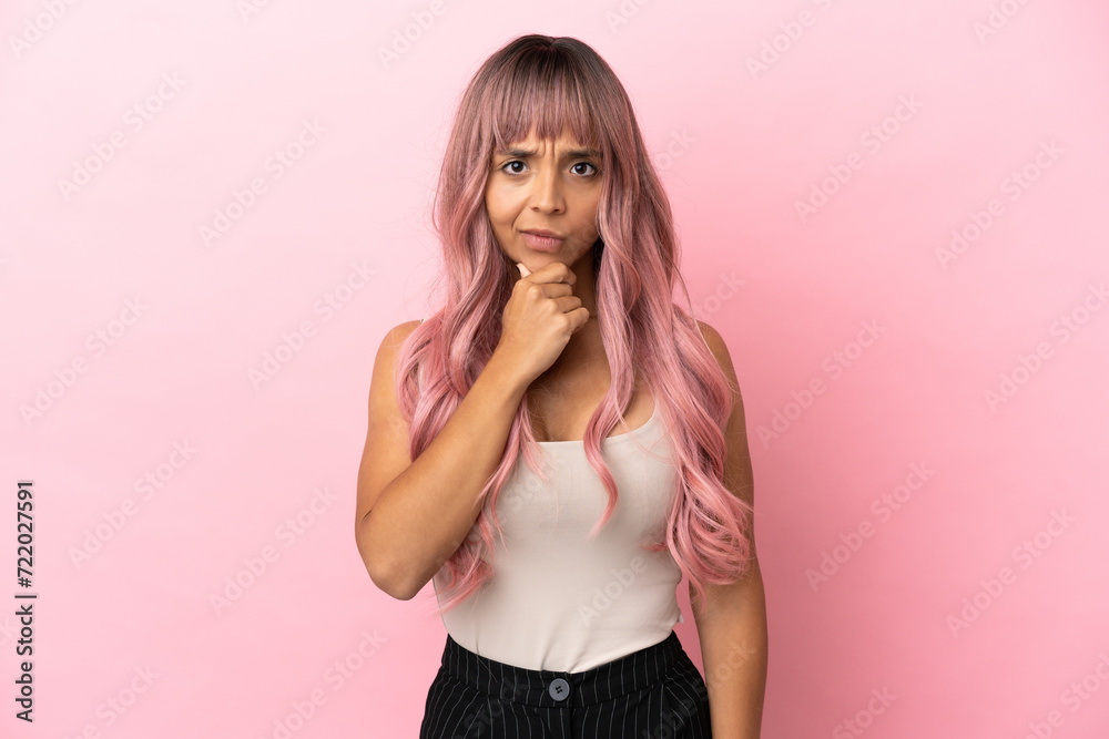 Young mixed race woman with pink hair isolated on pink background thinking Young mixed race woman with pink hair isolated on pink background thinking