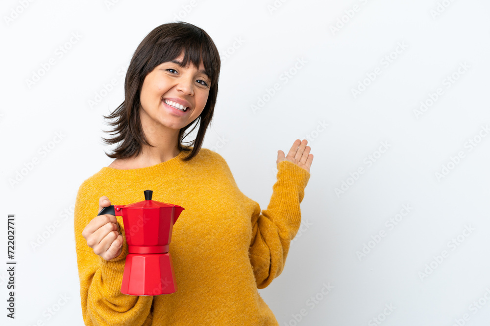 Young mixed race woman holding coffee pot isolated on white background extending hands to the side for inviting to come Young mixed race woman holding coffee pot isolated on white background extending hands to the side for inviting to come