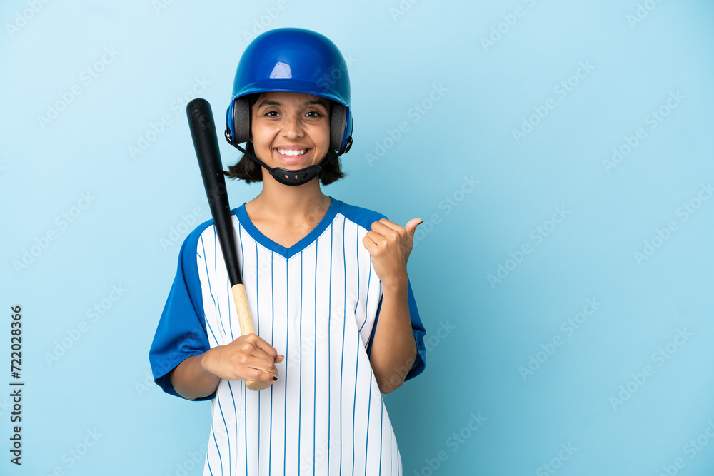 Baseball mixed race player woman with helmet and bat isolated on blue background pointing to the side to present a product Baseball mixed race player woman with helmet and bat isolated on blue background pointing to the side to present a product