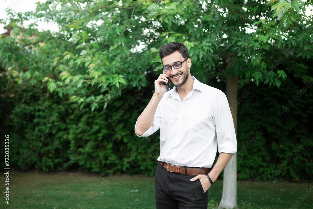Close up portrait of handsome bearded businessman in official wear talking on mobile phone outdoors Close up portrait of handsome bearded businessman in official wear talking on mobile phone outdoors