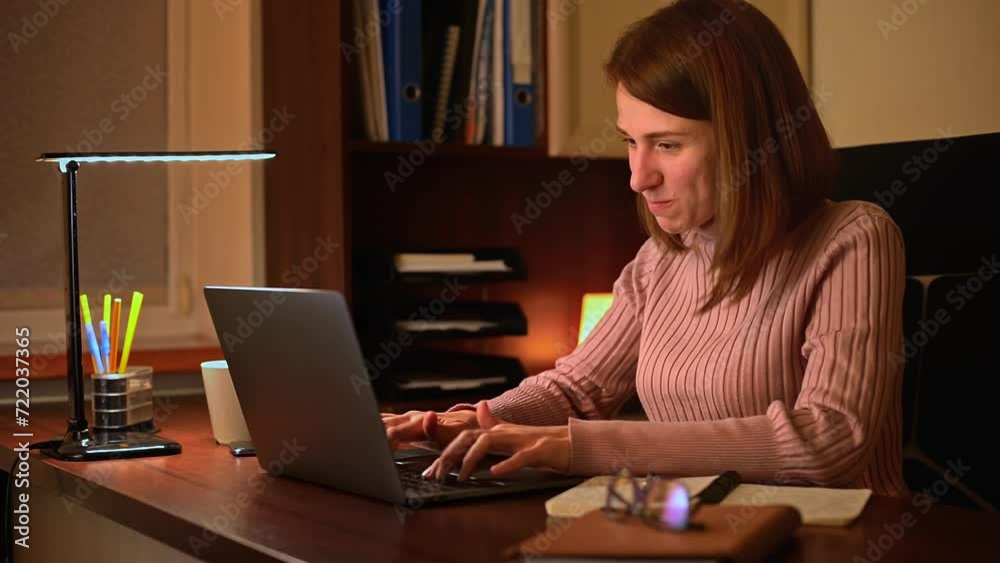 A young caucasian woman is seen working at her desk in an office. She is focused and determined, and as she completes her work, she becomes happy and satisfied with her accomplishments. A young caucasian woman is seen working at her desk in an office. She is focused and determined, and as she completes her work, she becomes happy and satisfied with her accomplishments.