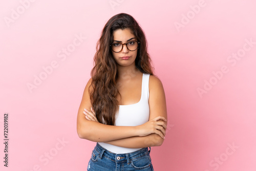 Young caucasian woman isolated on pink background feeling upset