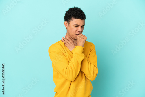 Young African American man isolated on blue background coughing a lot