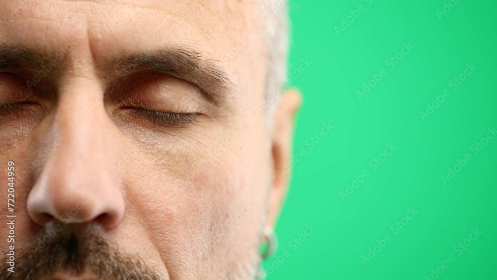 Fototapeta premium Man's eyes, close-up, on a green background