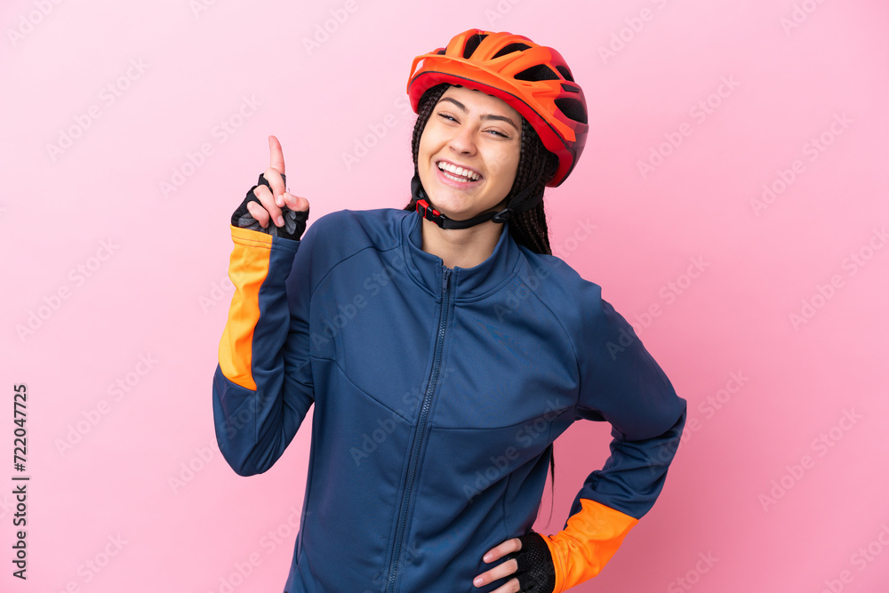 Teenager cyclist girl isolated on pink background showing and lifting a finger in sign of the best Teenager cyclist girl isolated on pink background showing and lifting a finger in sign of the best