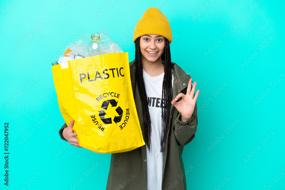 Teenager girl with braids holding a bag to recycle showing ok sign with two hands Teenager girl with braids holding a bag to recycle showing ok sign with two hands