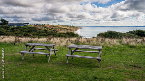 Picnic benches with views of the cliffs and Naish Beach in Highcliffe, Dorset, England, UK photo