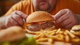 a close-up of a burger and fast food in front of a fat man about to eat it all.