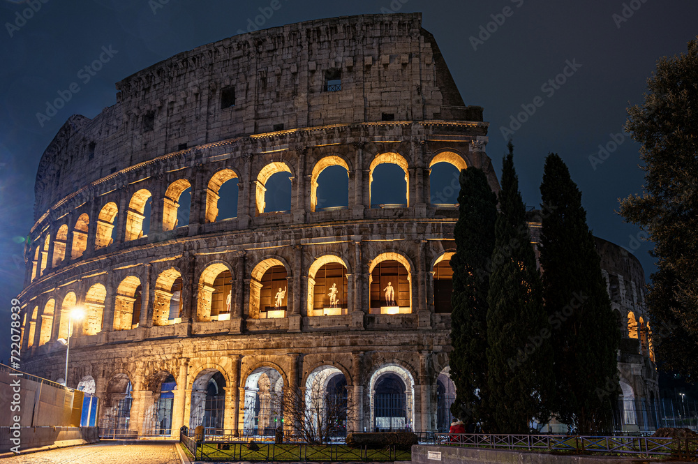 The majestic Rome Colosseum stands illuminated against the night sky in Italy