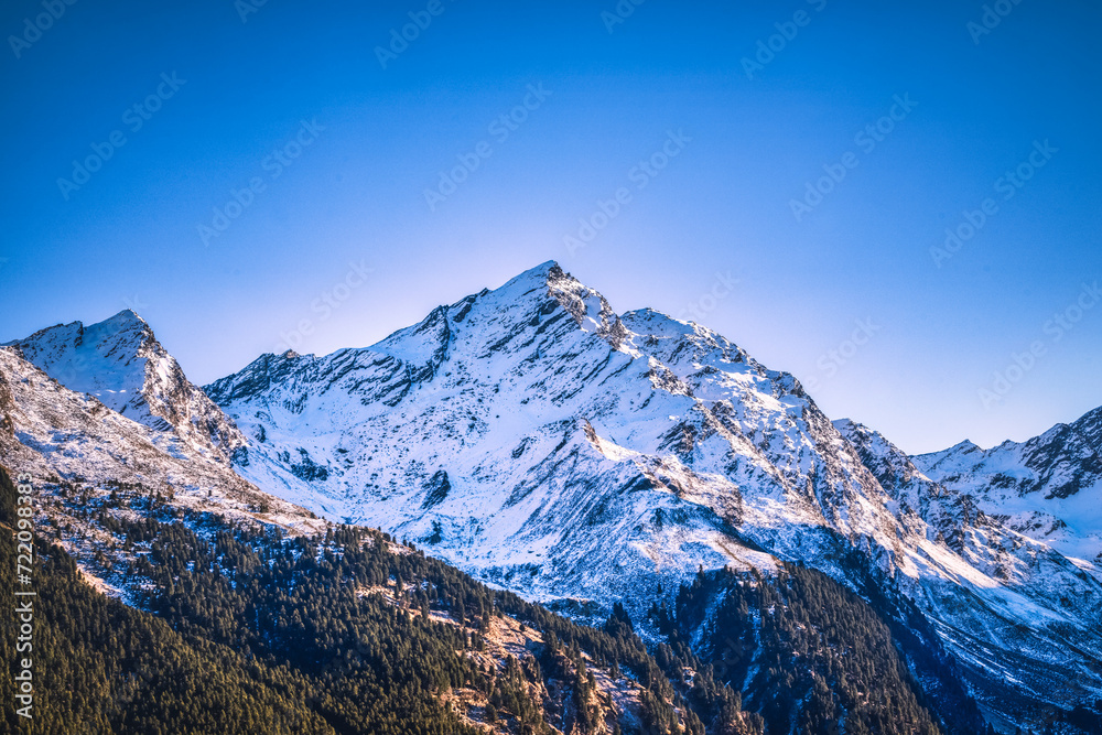 Snowy mountain with adjacent trees in the distance, Tyrol, Austria